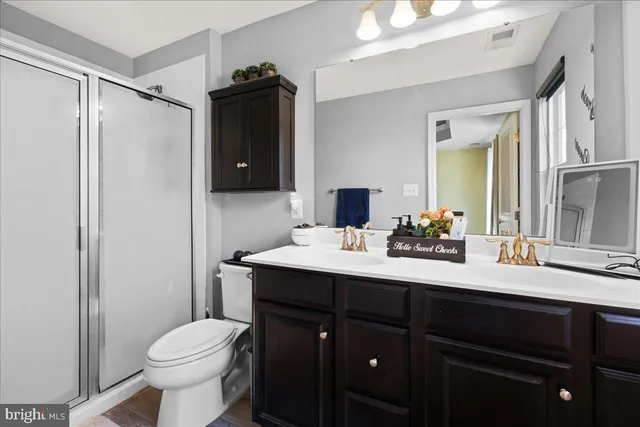 a bathroom with a sink vanity toilet and shower
