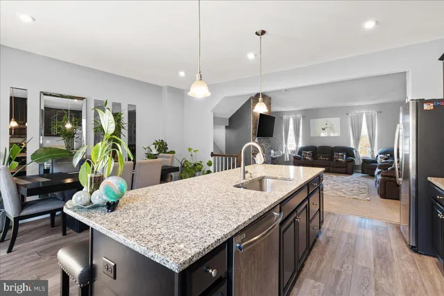 a kitchen island with granite countertop a table and chairs in it