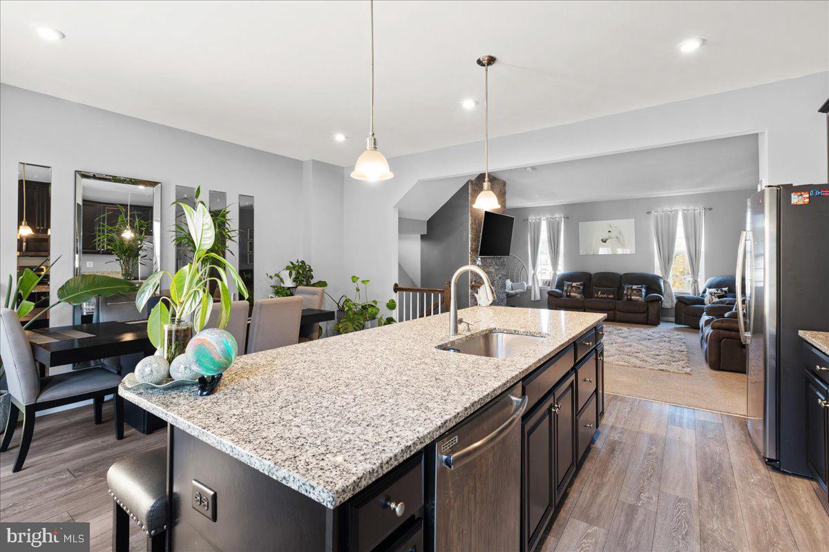 26 Quebec Court Falling Waters, WV 25419 - Photo 8 of 29 a kitchen island with granite countertop a table and chairs in it