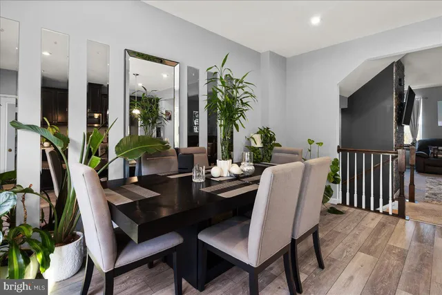 a dining room with furniture potted plants and wooden floor