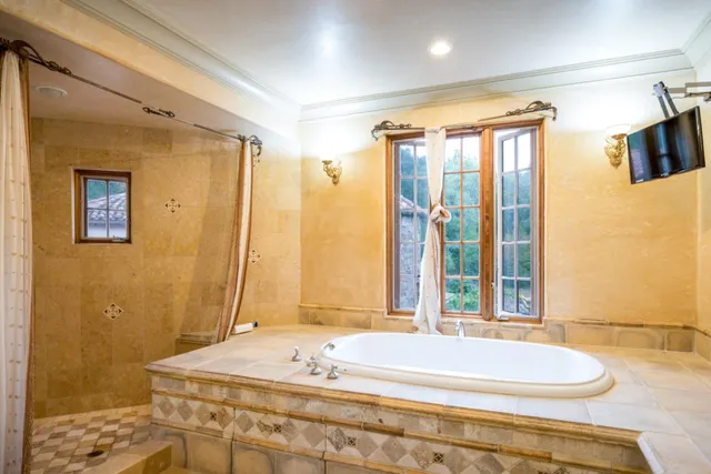 a bathroom with a granite countertop sink and a bathtub