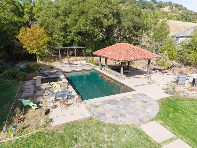 a view of a patio with a table and chairs under an umbrella