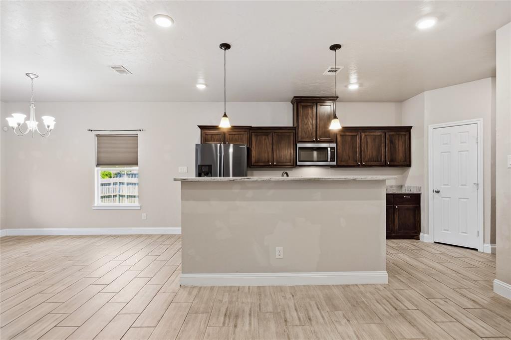 1502 Reed Street Greenville, TX 75401 - Photo 9 of 26 Open-concept living space with wood-finish tile flooring throughout