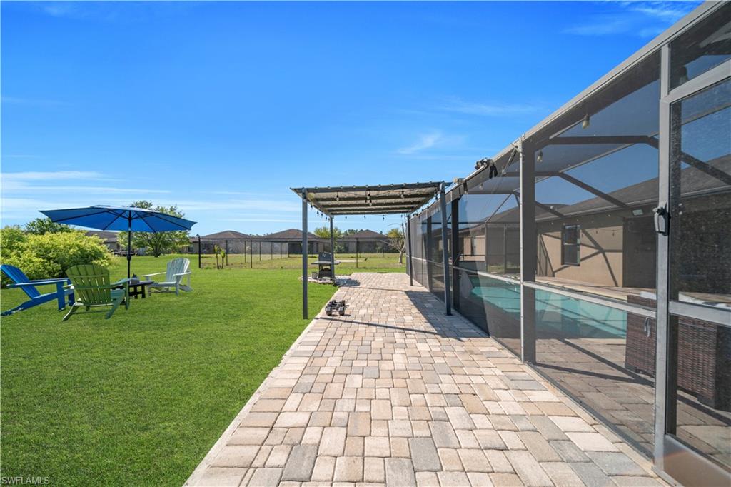 175 Shadowview Court Lehigh Acres, FL 33974 - Photo 11 of 39 Fenced backyard featuring a patio, a lanai, an outdoor pool, and a sunroom