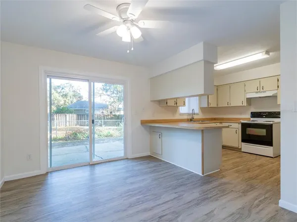 a kitchen with granite countertop a stove top oven and cabinets
