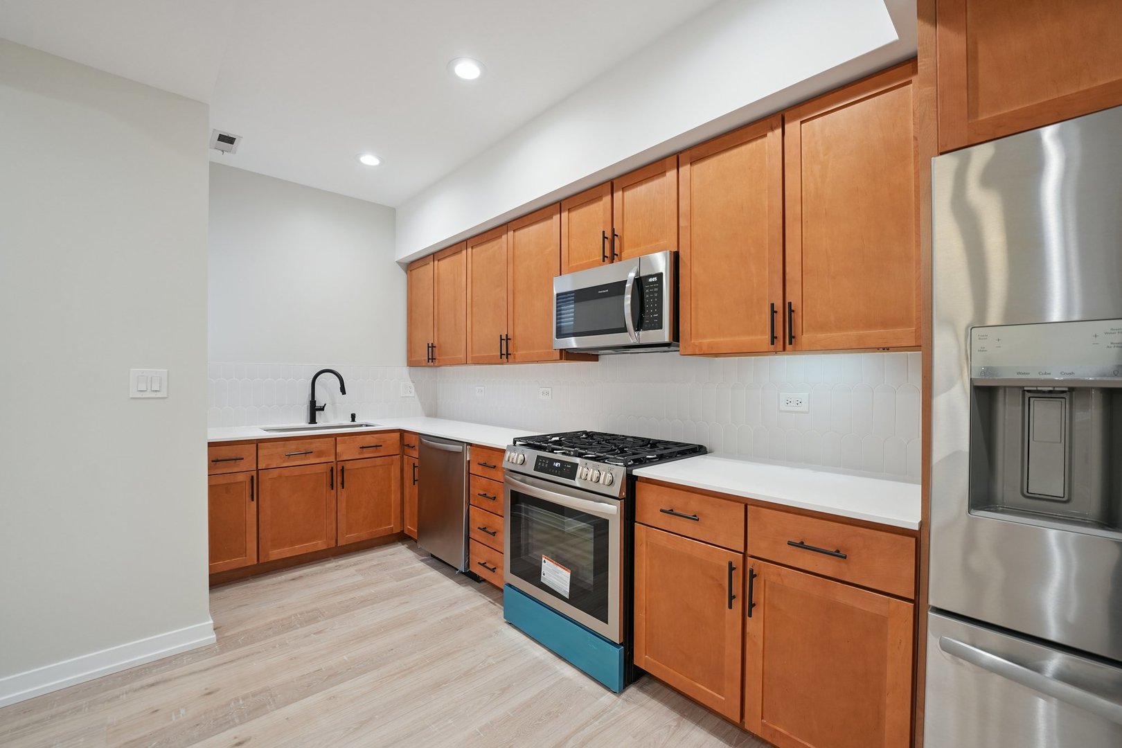 1635 West Warren Boulevard, Unit 1 Chicago, IL 60612 - Photo 2 of 14 a kitchen with stainless steel appliances granite countertop a stove a sink and a refrigerator