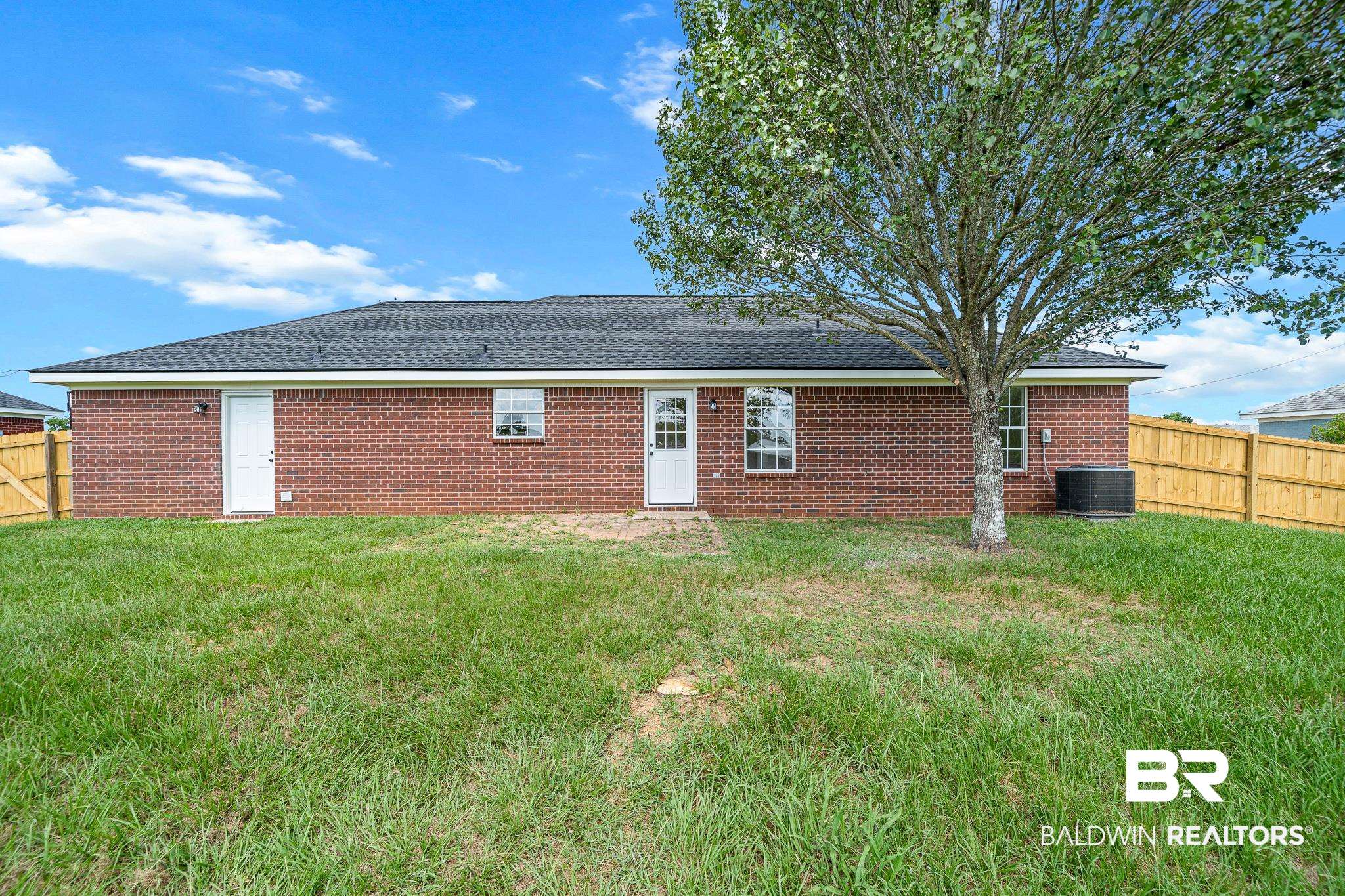 8921 Sherman Road Foley, AL 36535 - Photo 16 of 19 Back of house with central AC unit and a lawn