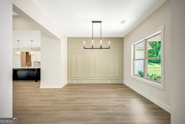 a large kitchen with stainless steel appliances kitchen island a large counter top and a wooden floors