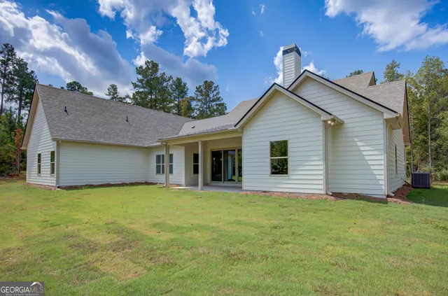 a view of a livingroom with wooden floor a ceiling fan and windows