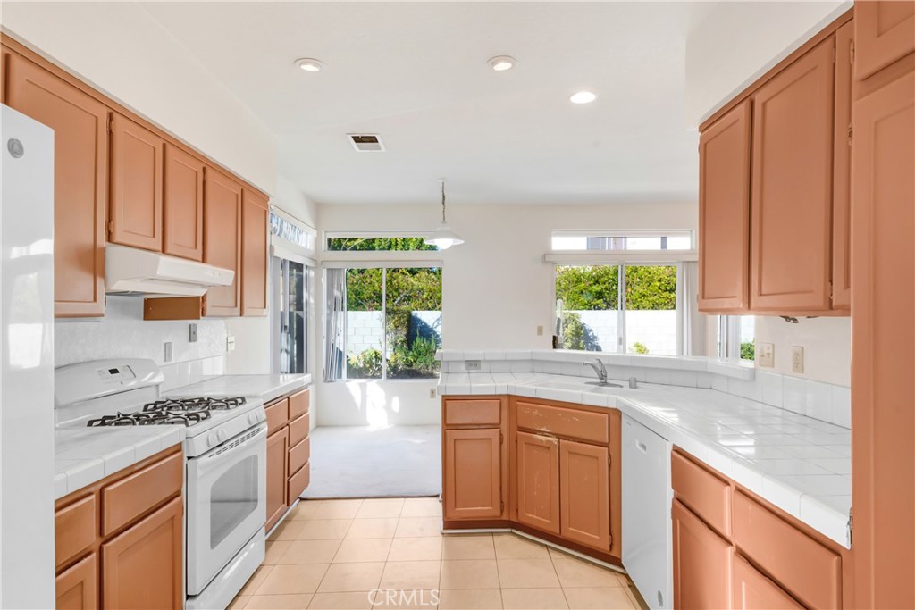 69860 Mccallum Way Cathedral City, CA 92234 - Photo 10 of 25 a large kitchen with stainless steel appliances granite countertop a stove a sink and a refrigerator