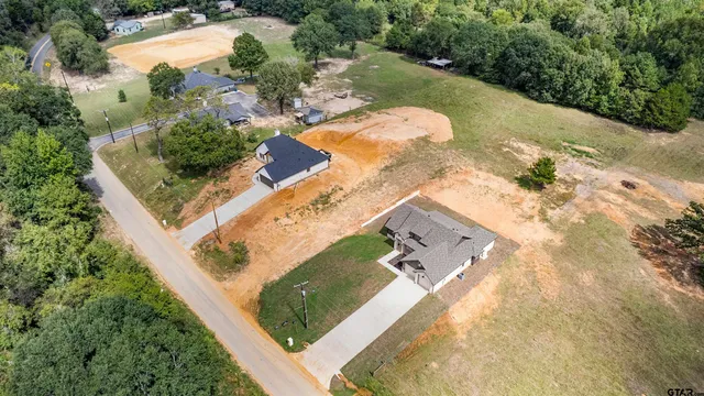 an aerial view of a house with a yard and lake view