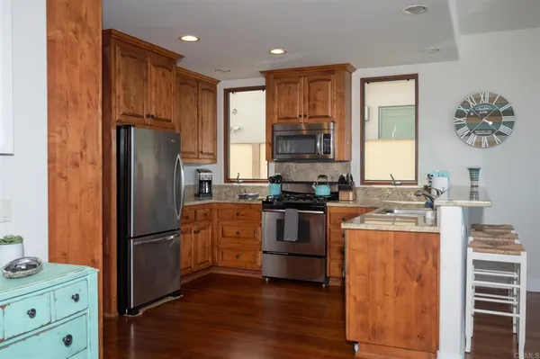 a kitchen with stainless steel appliances granite countertop a refrigerator stove and sink