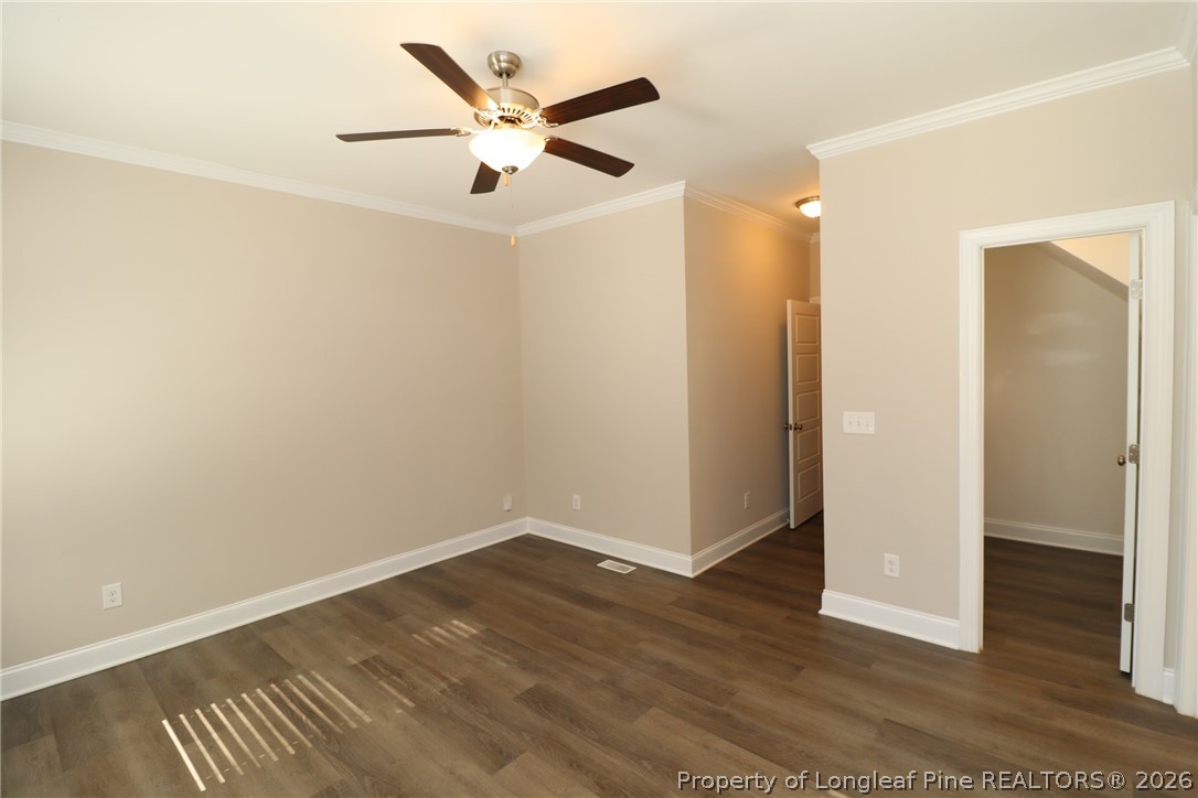 8424 Rhodes Road Apex, NC 27539 - Photo 16 of 31 an empty room with wooden floor and a ceiling fan