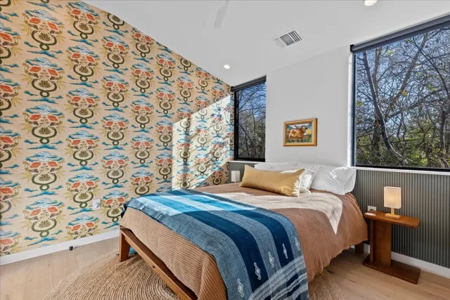 a bedroom with a bed and a painting on the wall