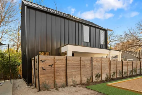 a view of a wooden house with a large tree