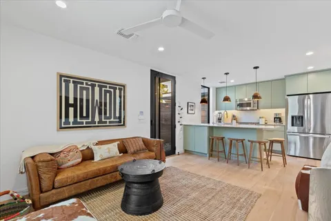 a living room with furniture a refrigerator and kitchen view