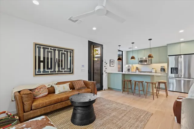 a living room with furniture a refrigerator and kitchen view