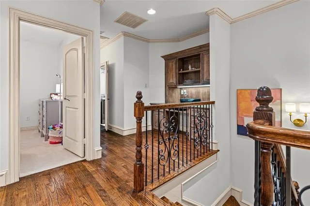 a view of a hallway with wooden floor and stairs