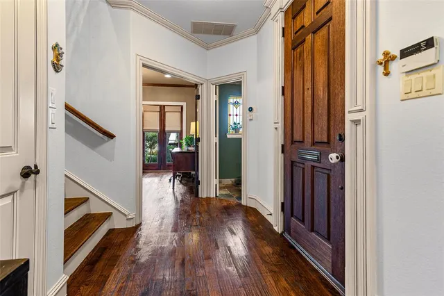 a view of a hallway with wooden floor and staircase