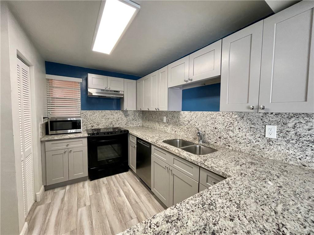 1990 West 56th Street, Unit 1205 Hialeah, FL 33012 - Photo 1 of 16 a kitchen with stainless steel appliances granite countertop a sink stove and oven