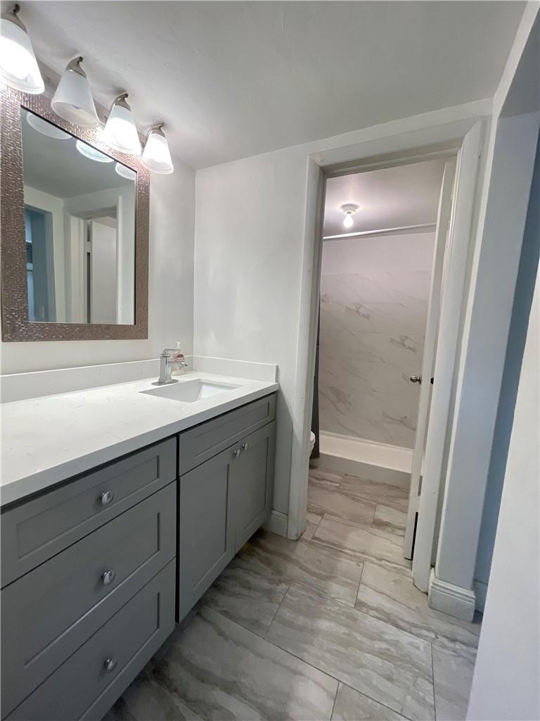 1990 West 56th Street, Unit 1205 Hialeah, FL 33012 - Photo 6 of 16 a bathroom with a double vanity sink and mirror with shower