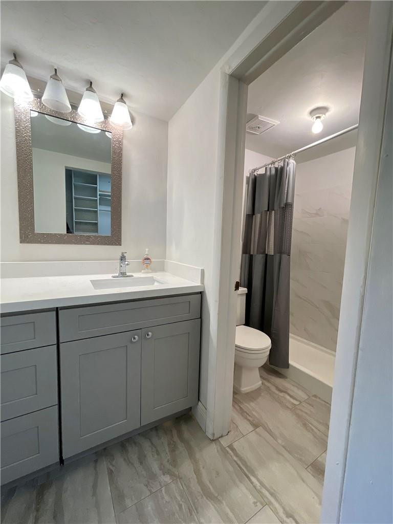 1990 West 56th Street, Unit 1205 Hialeah, FL 33012 - Photo 8 of 16 a bathroom with a toilet sink and mirror