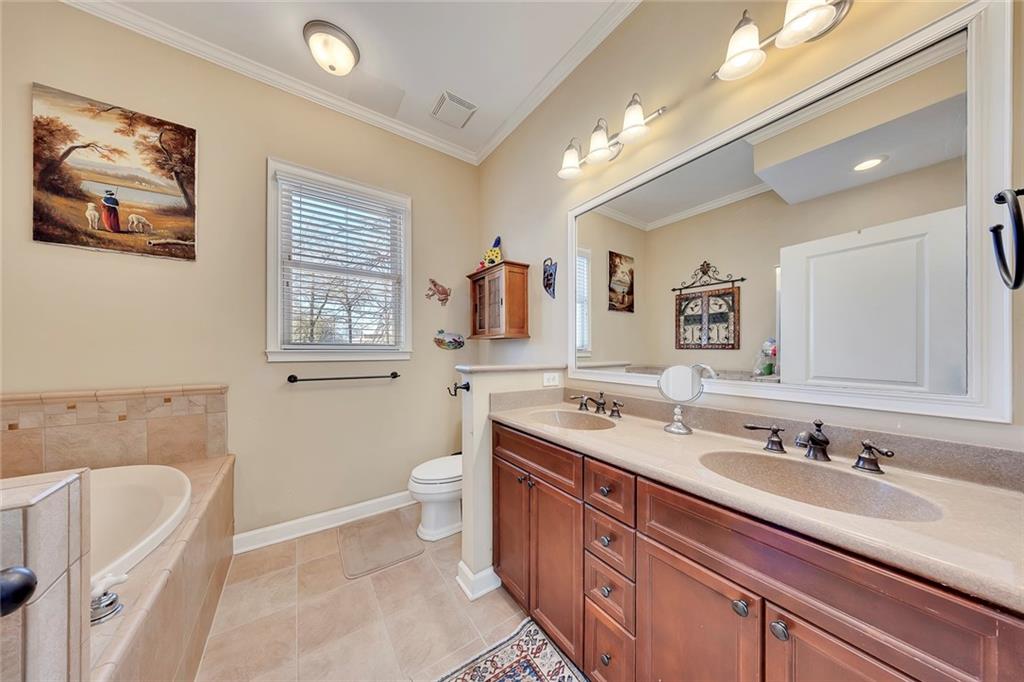 11 Perimeter Centre East, Unit 1112 Atlanta, GA 30346 - Photo 19 of 38 a bathroom with a sink double vanity granite tub and a toilet