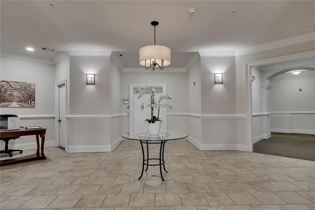 a view of a hallway with seating area chandelier and living room view