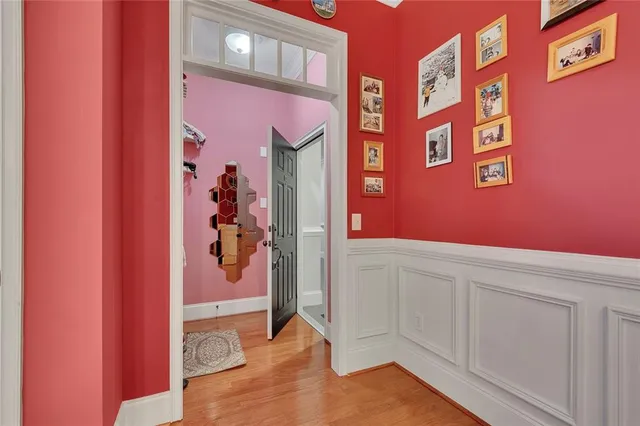 a kitchen with stainless steel appliances granite countertop a refrigerator a sink dishwasher a dining table and chairs with wooden floor