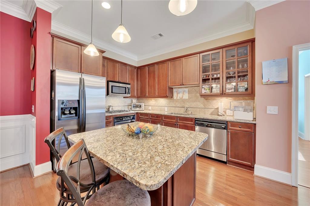 11 Perimeter Centre East, Unit 1112 Atlanta, GA 30346 - Photo 9 of 38 a kitchen with granite countertop kitchen island stainless steel appliances a stove refrigerator sink and cabinets
