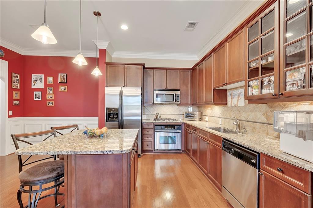 11 Perimeter Centre East, Unit 1112 Atlanta, GA 30346 - Photo 10 of 38 a kitchen with granite countertop kitchen island stainless steel appliances a sink stove and refrigerator