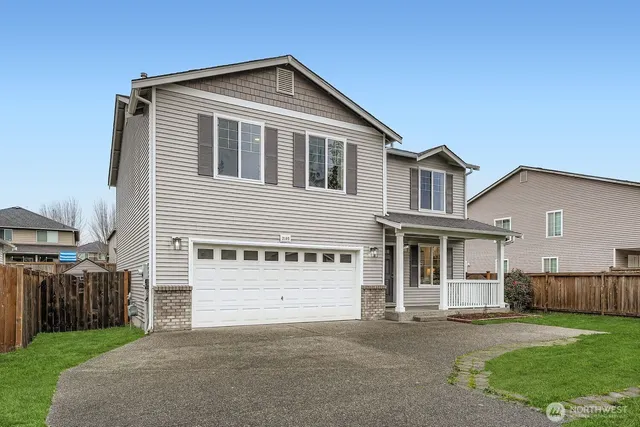 a front view of a house with a yard and garage