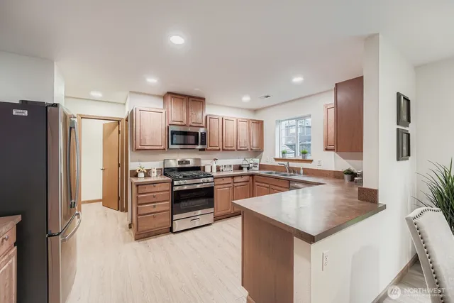 a kitchen with a refrigerator a stove top oven a sink and cabinets