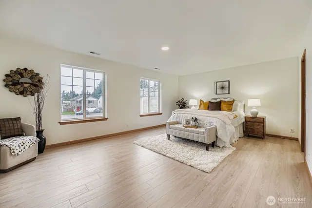 a bedroom with a bed and wooden floor