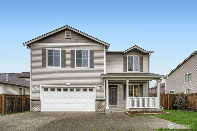 a front view of a house with a yard and garage