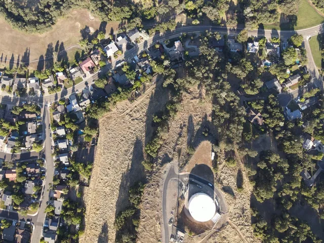 a aerial view of a house with a yard and fountain