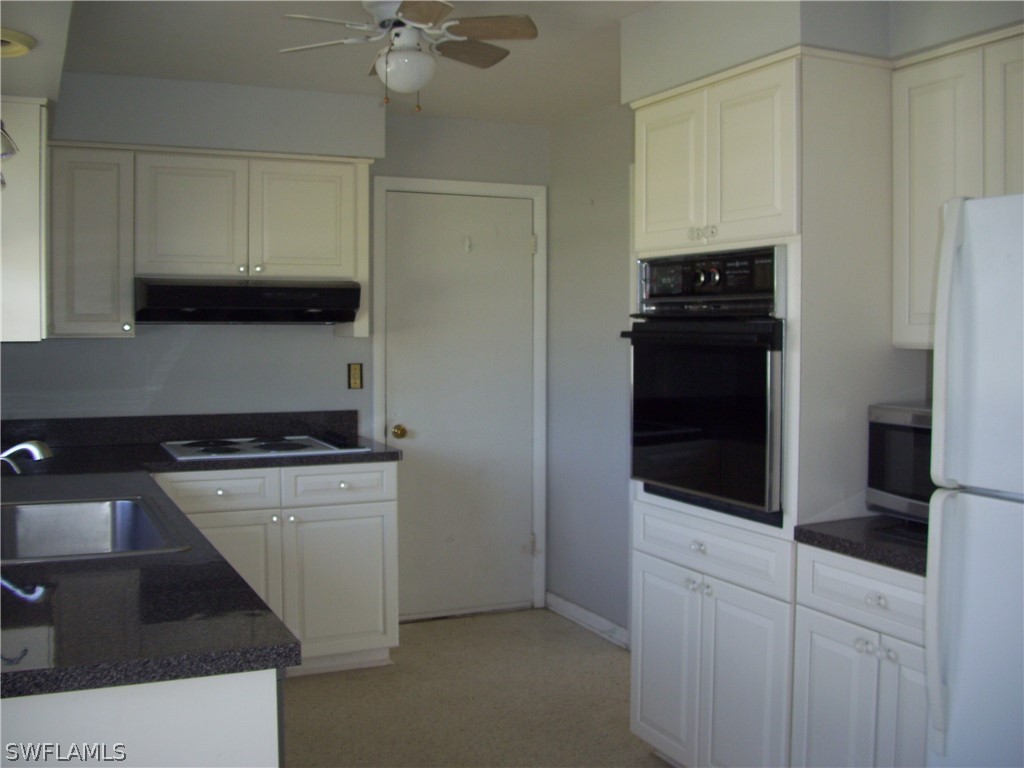 1448 Charles Road Fort Myers, FL 33919 - Photo 11 of 26 a kitchen with a stove and a refrigerator