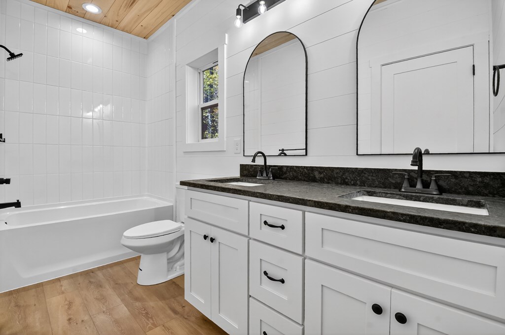 85 Duck Cove Morganton, GA 30560 - Photo 29 of 36 a bathroom with a granite countertop toilet a sink and a bathtub