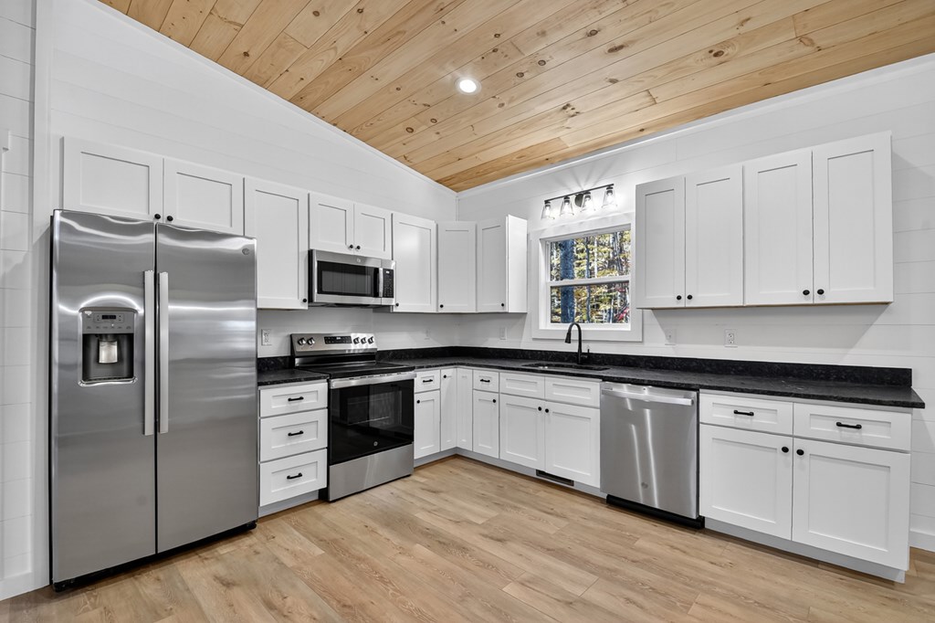 85 Duck Cove Morganton, GA 30560 - Photo 5 of 36 a kitchen with stainless steel appliances granite countertop a stove a sink dishwasher a refrigerator and a microwave oven with wooden floor