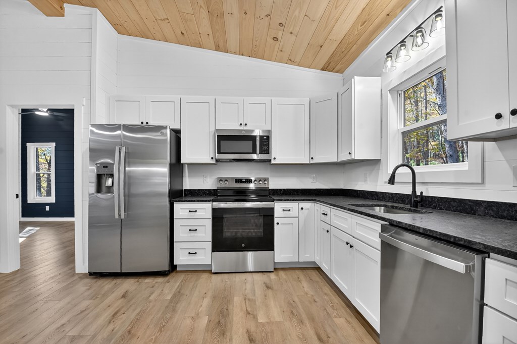 85 Duck Cove Morganton, GA 30560 - Photo 8 of 36 a kitchen with stainless steel appliances granite countertop a refrigerator a sink a stove a microwave and wooden floors