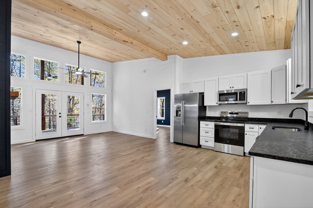 85 Duck Cove Morganton, GA 30560 - Photo 9 of 36 a kitchen with stainless steel appliances granite countertop a refrigerator a stove oven a sink dishwasher and white cabinets with wooden floor
