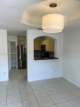 a kitchen with granite countertop a refrigerator and a stove top oven