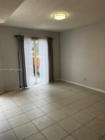 a kitchen with granite countertop a refrigerator and a stove top oven