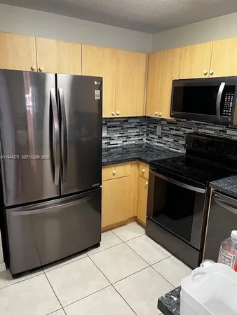 a kitchen with a refrigerator and a sink