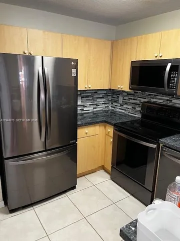 a kitchen with stainless steel appliances granite countertop a stove microwave and refrigerator
