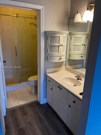 a view of empty room with wooden floor and door