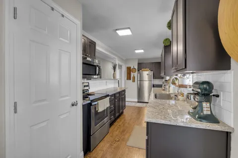 a kitchen with stainless steel appliances granite countertop a sink stove and refrigerator