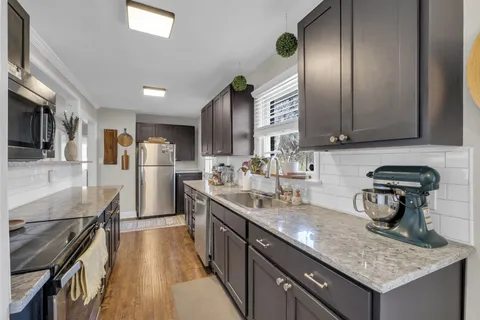 a kitchen with stainless steel appliances granite countertop a sink stove and refrigerator