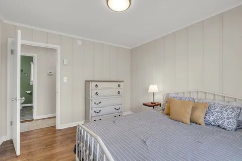 a bedroom with a bed and wooden floor