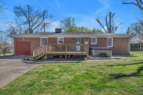 a view of a house with a patio and a yard